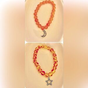 Qty. 2: 1 orange, 1 Amber Baltic w/ silver moon, star charms, dtretch bracelets.